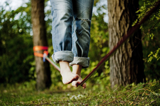 Low section of man walking on tightrope at park