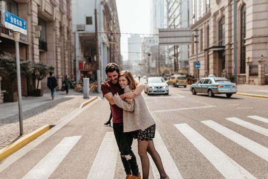 Beautiful couple hugging on crosswalk