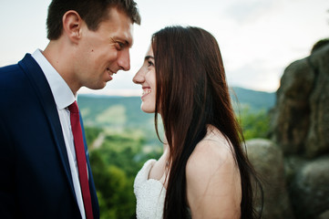 Lovely wedding couple against rocks of fortess Tustan at Carpathian mountains.