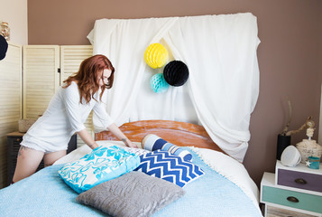 Jeune femme fait son lit