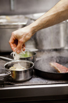 Cropped hand of chef preparing food at commercial kitchen