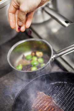 Cropped image of chef cooking at commercial kitchen counter
