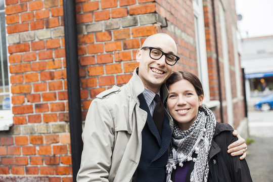 Portrait of happy couple standing against building