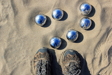 Foots in front of petanque balls. View from the top