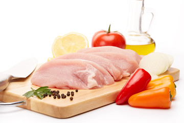 Raw turkey meat fillet and vegetables.