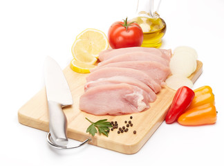 Raw turkey meat fillet and vegetables.