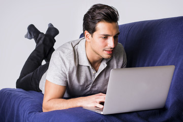 Young man working with computer on couch