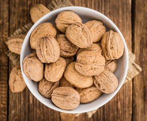 Portion of Whole Walnuts on wooden background (selective focus)