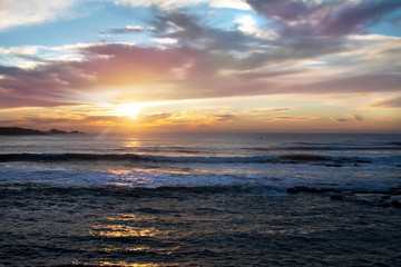 beautiful colorful sunset in ocean with stormy clouds and sun beams background. Morocco