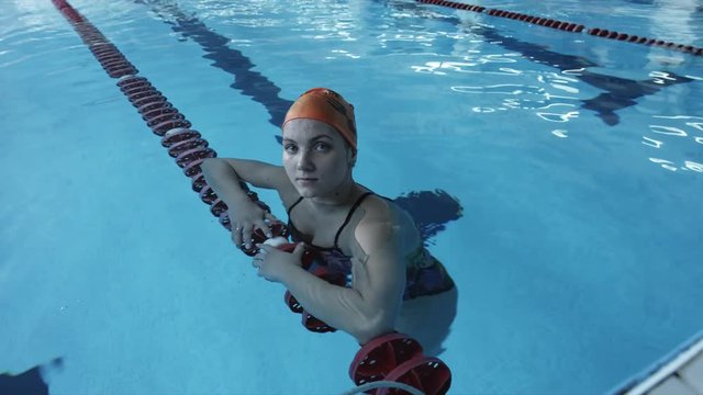 Girl swimmer looking at camera in the swimming pool
