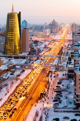 A view from above on a large avenue that goes down to the horizon, and a golden skyscraper of minestry in Astana, Kazakhstan.