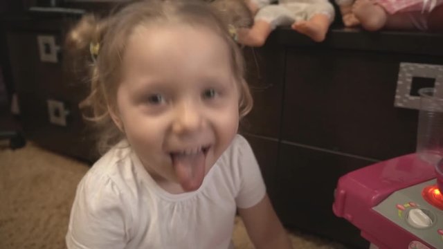 The girl shows your tongue, touch it with your hands