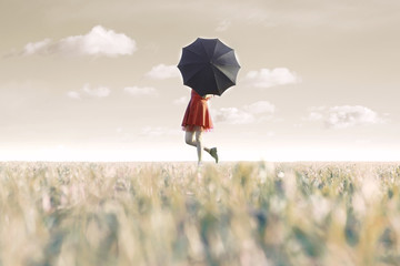 woman hides behind his black umbrella in a surreal place