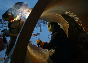 Workers are welding inside and outside of the pipe
