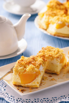 Cheesecake with peaches on blue wooden background.