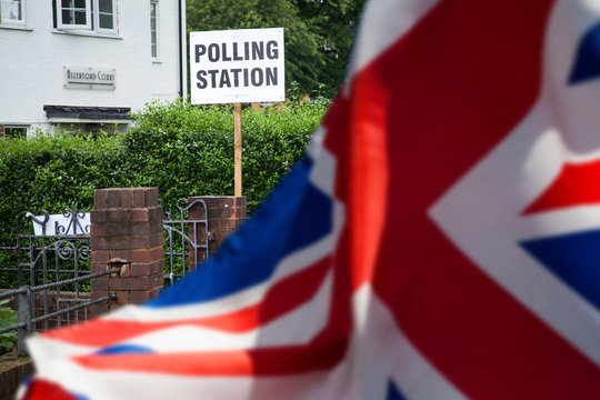 polling station sign and Union Jack flag - UK prepares for elections - Powered by Adobe