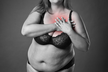 Fat woman with heart attack, pain in chest, overweight female body on gray background