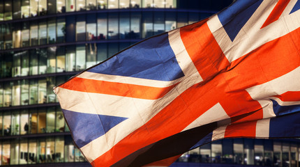 union jack flag over London financial district with iconic skyscrapers, UK prepares for elections after Brexit