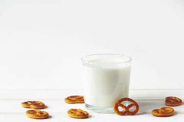 glass of milk and cookies against white wall on a white table