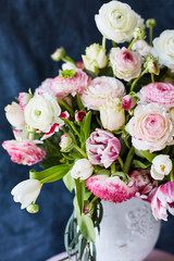 Flower arrangement with tulips and ranunculus on a white wooden floor. Spring flower 