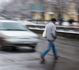 Man on zebra crossing in a rainy day