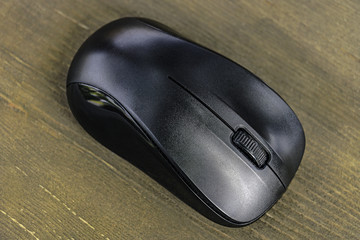 Wireless black mouse on wooden table