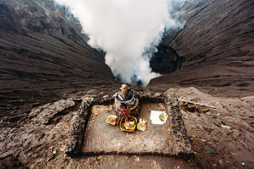 Crater of Bromo volcano and Ganesha altar with offerings in Bromo Tengger Semeru National Park, East Java, Indonesia. Erupting and active volcano © linortis