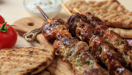 Grilled meat skewers on a wooden surface