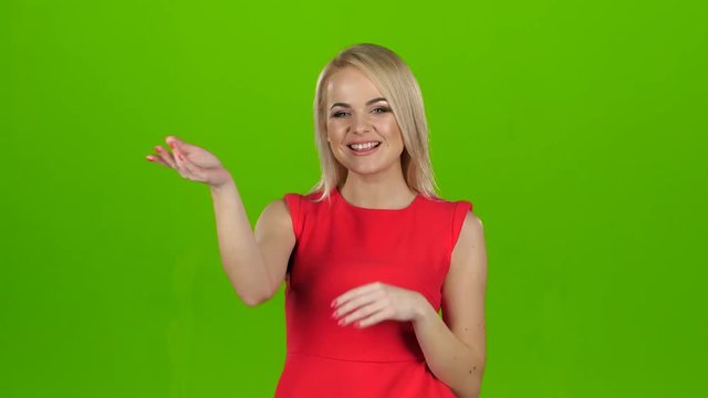 Blonde in a red dress gives out kisses. Green screen