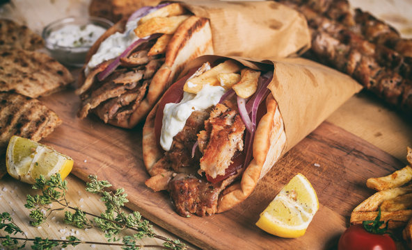 Greek gyros wrapped in pita breads on a wooden table