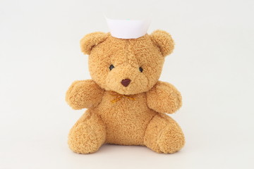 Teddy bear wearing a nurse hat on a white background.
