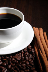 Coffee cup, coffee beans and cinnamon.
