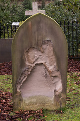 Heavily eroded grave headstone