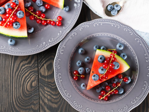 Slice of watermelon served as cake or pizza with fresh berries on rustic background