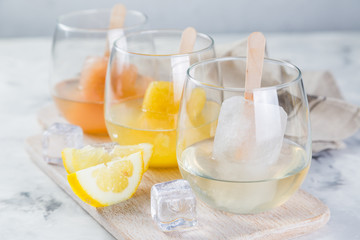 Colorful ice popsicles with wine in glasses