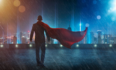 Businessman in a suit and cape hero facing a storm,victory concept. cityscape background , night scene . - obrazy, fototapety, plakaty