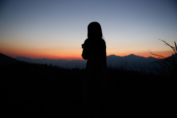 Fototapeta premium sunset silhouette, young lady in hill