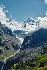 Snow capped alpine mountains. Trek near Matterhorn mount. View of the mountain and valley of a mountain river. Beautiful alpine landscape with a mountain path, Swiss Alps, Europe