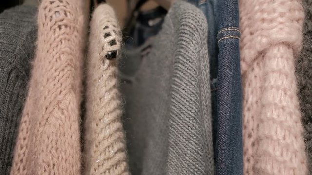 On the hanger hang warm woolen and denim things for women. In the wardrobe are sweaters, pullovers and cardigans, which are used in the cold season to warm the body. On the shoulders are installed