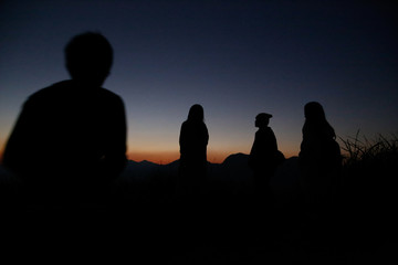 Watch the evening with a group on a hill