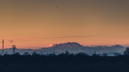 Naklejka premium airplane over the mountains - italian alps - travel concept