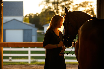 Woman and horse in barn
