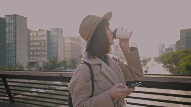 Fashion industry office worker drinks artisanal speciality coffee from take away mug on the way to work and takes relaxing breats of air to calm and focus before a busy day.