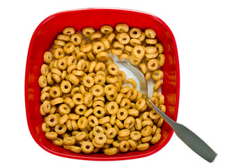 Red bowl of cereal with milk and a spoon isolated on white