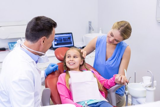 Dentist interacting with young patient