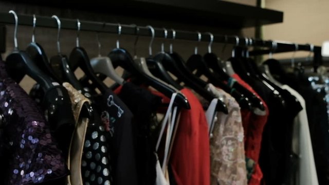 Original things for women hang on a hanger in a fashionable boutique. The dress shows the key as a print. A number of new clothes collection is ready for sale in the new season after the show on the