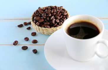 Coffee beans and black coffee in a white cup on the table