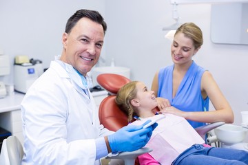 Fototapeta premium Dentist holding digital tablet in dental clinic