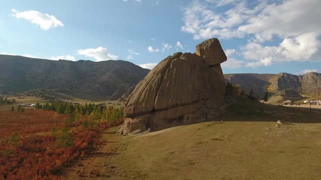 Park Terelj rocks and steppe near Ulaanbaatar Mongolia. Summer autumn sunny blue sky clouds colors. Beautiful Mongolian nature. Aerial drone helicopter around unique Turtle main famous rock attraction
