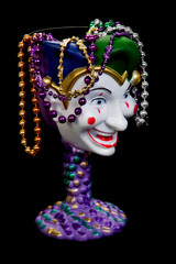 Jester mardi gras goblet with colored beans isolated on black